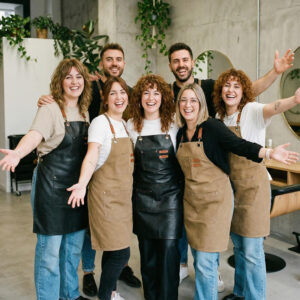 Grupo de estilistas dando la bienvenida a Peluquería unida